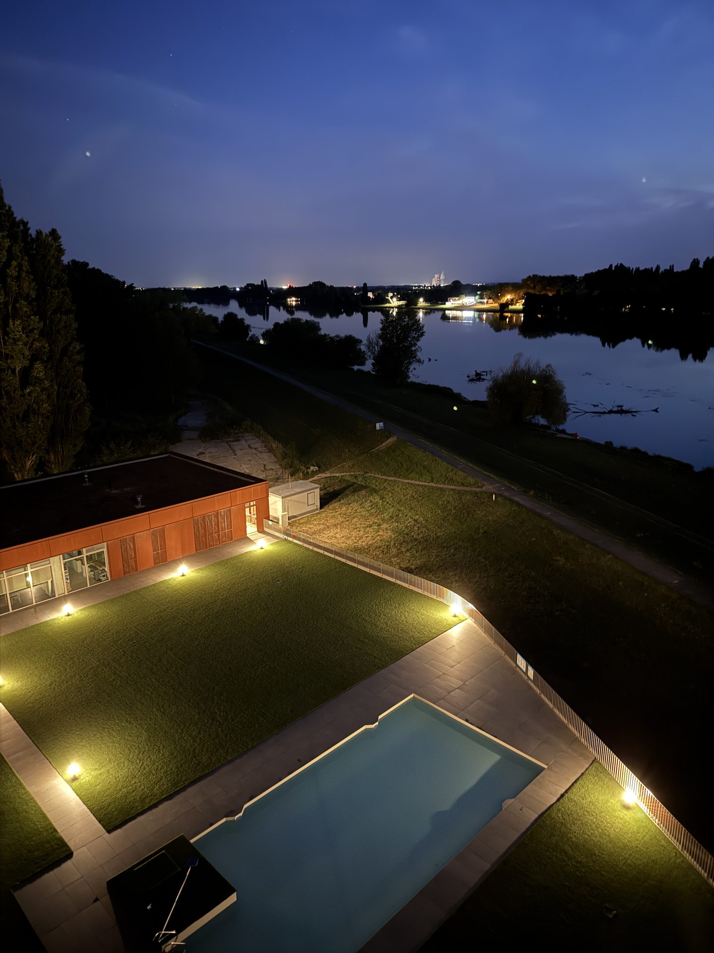 Nočný pohľad z terasy s bazénom a riekou